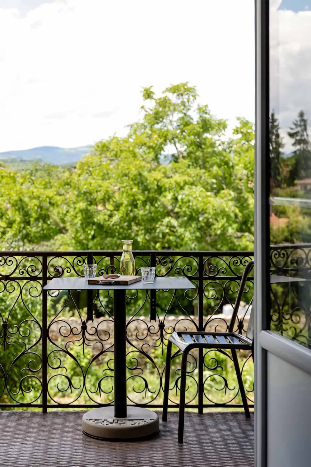 balcony of a country house arranged with a black Donut bistro table in aluminum and concrete