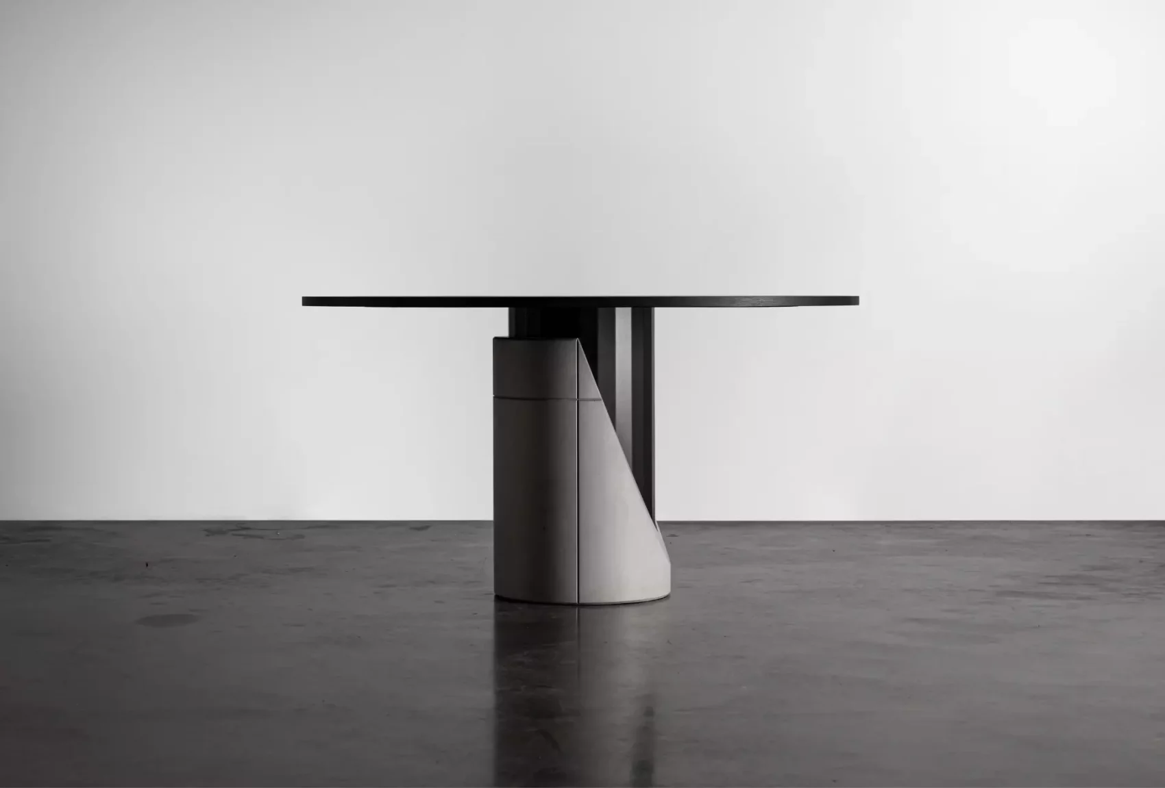 Dining table with a concrete base and black oak plated tabletop