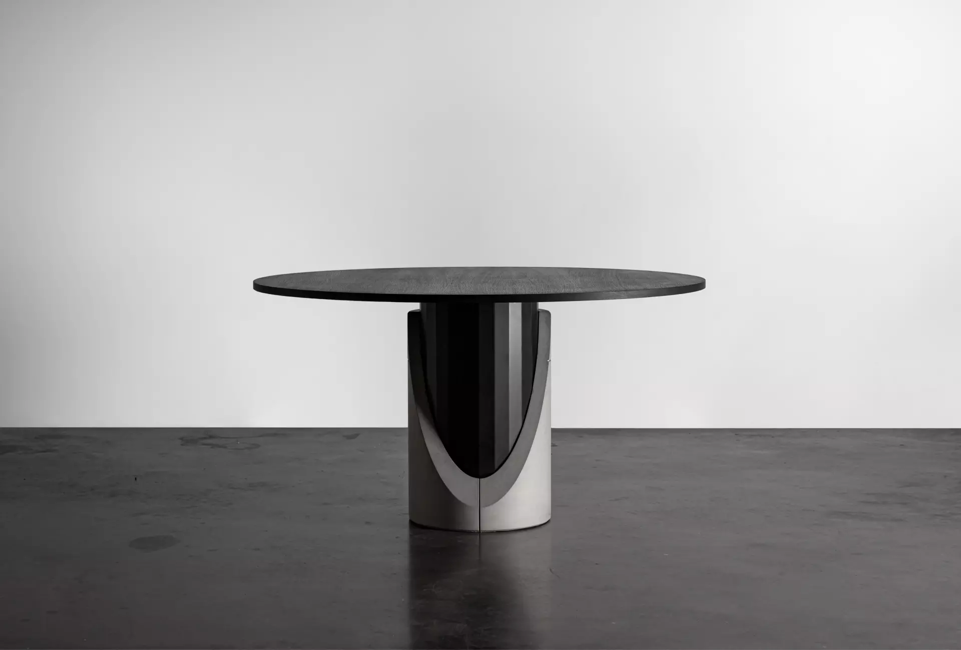 Dining table with a concrete base and black oak plated tabletop