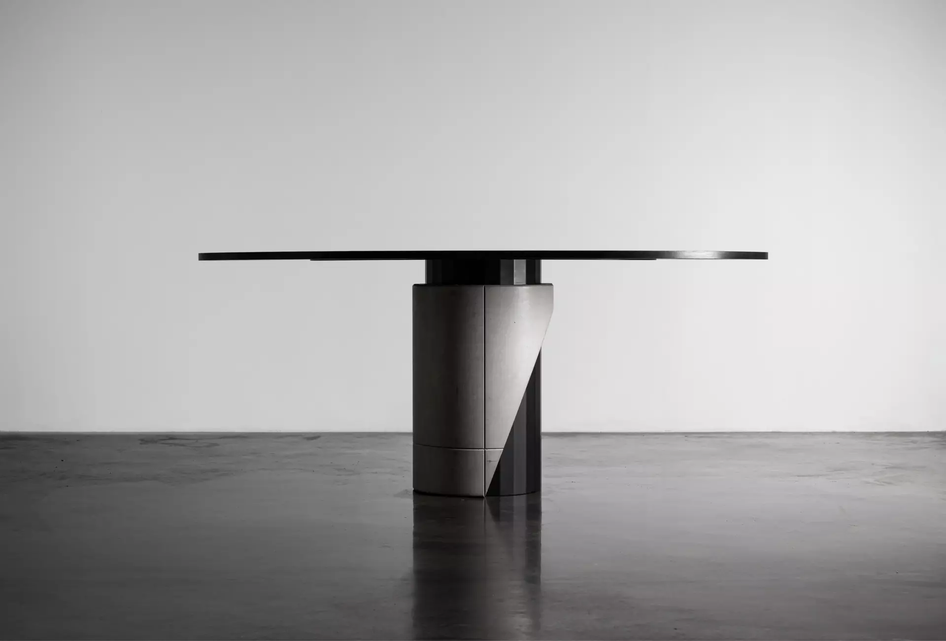 Dining table with a concrete base and black oak plated tabletop