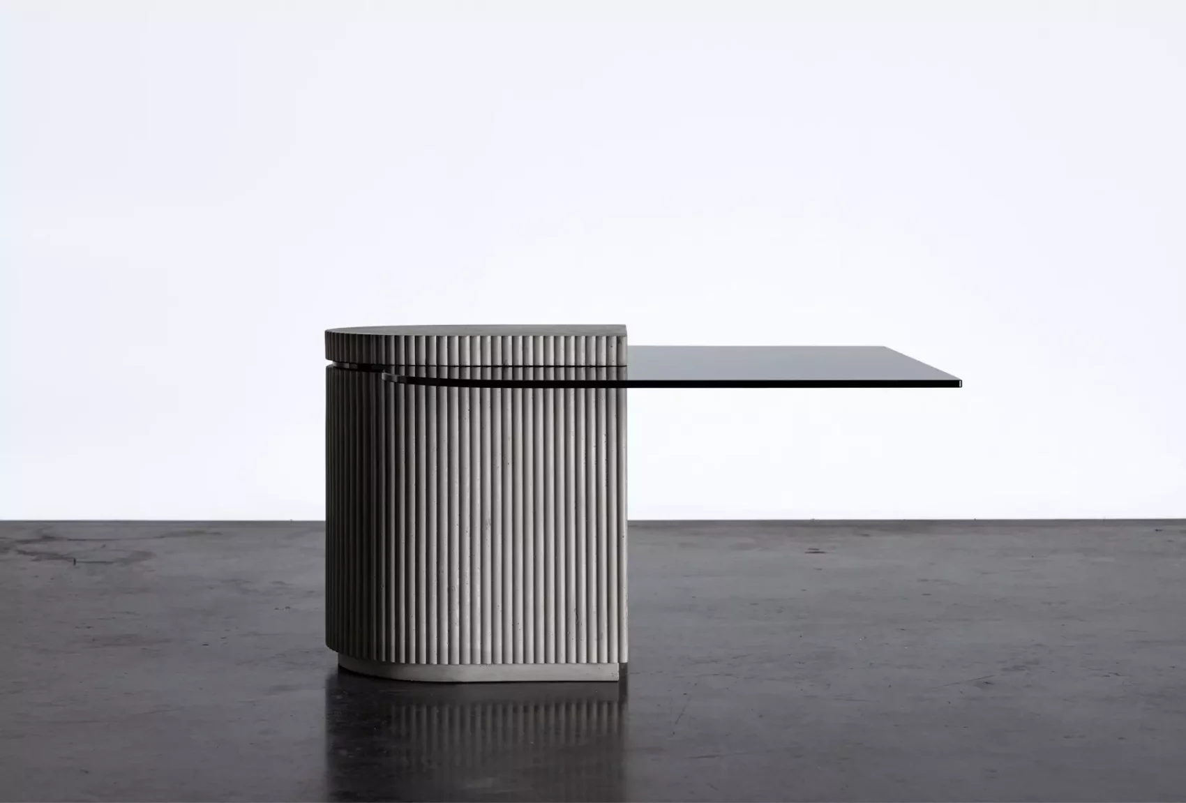 Concrete and hybrid glass cabinet between a coffee table and an extra table