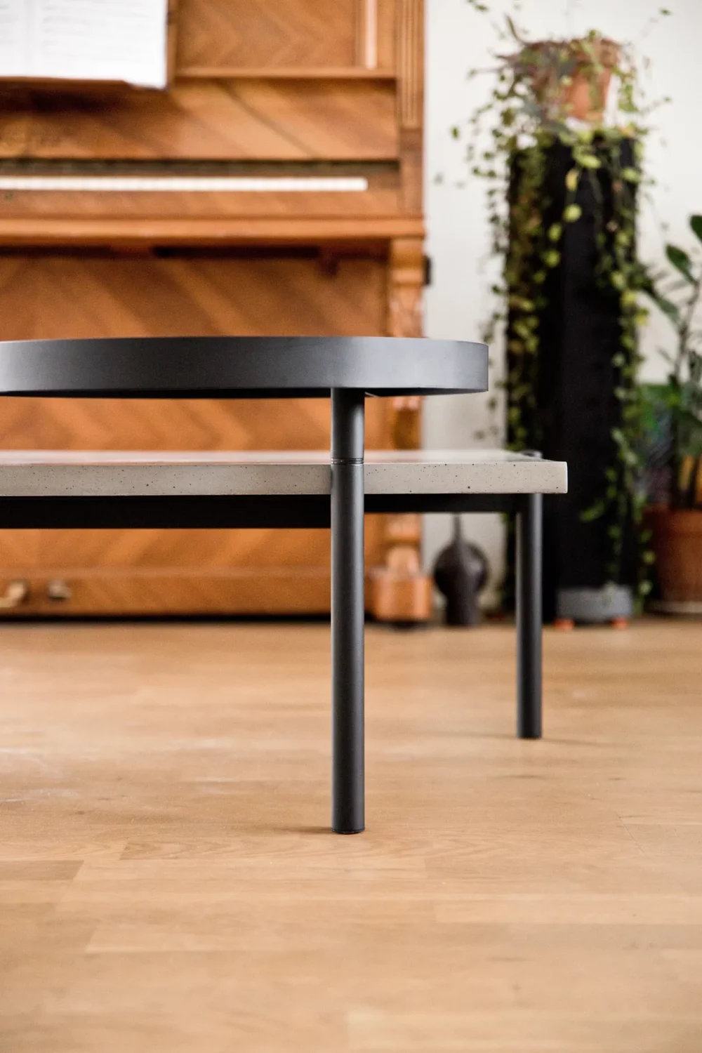 The slim profile of the Twist coffee table concrete top leaves room for the visible piano behind