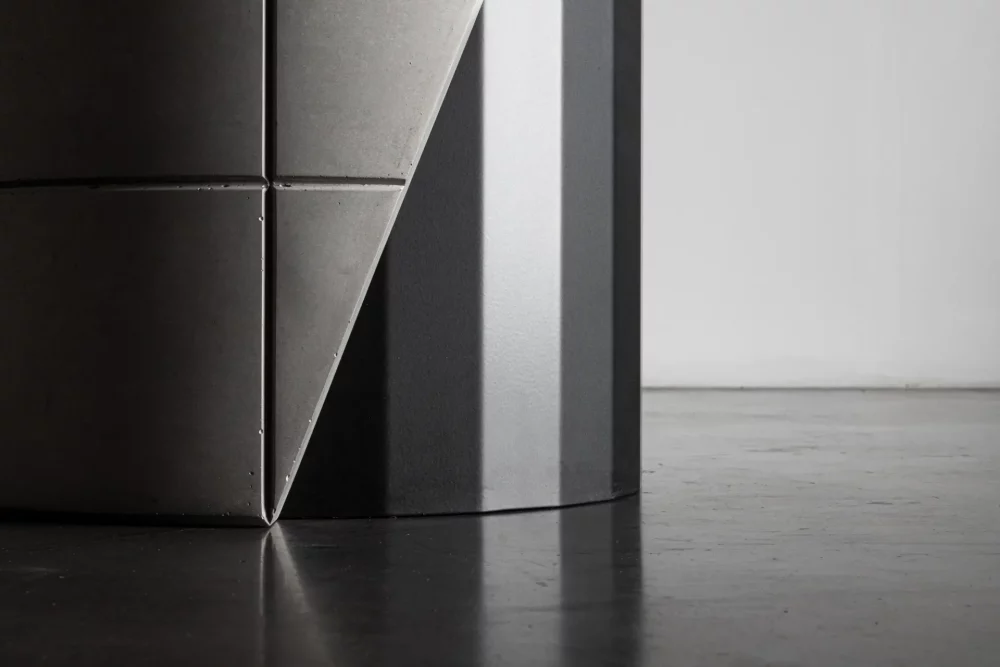 Brutalist detail of the concrete shell which covers the metal foot of the Sharp dining table by designer Bertrand Jayr