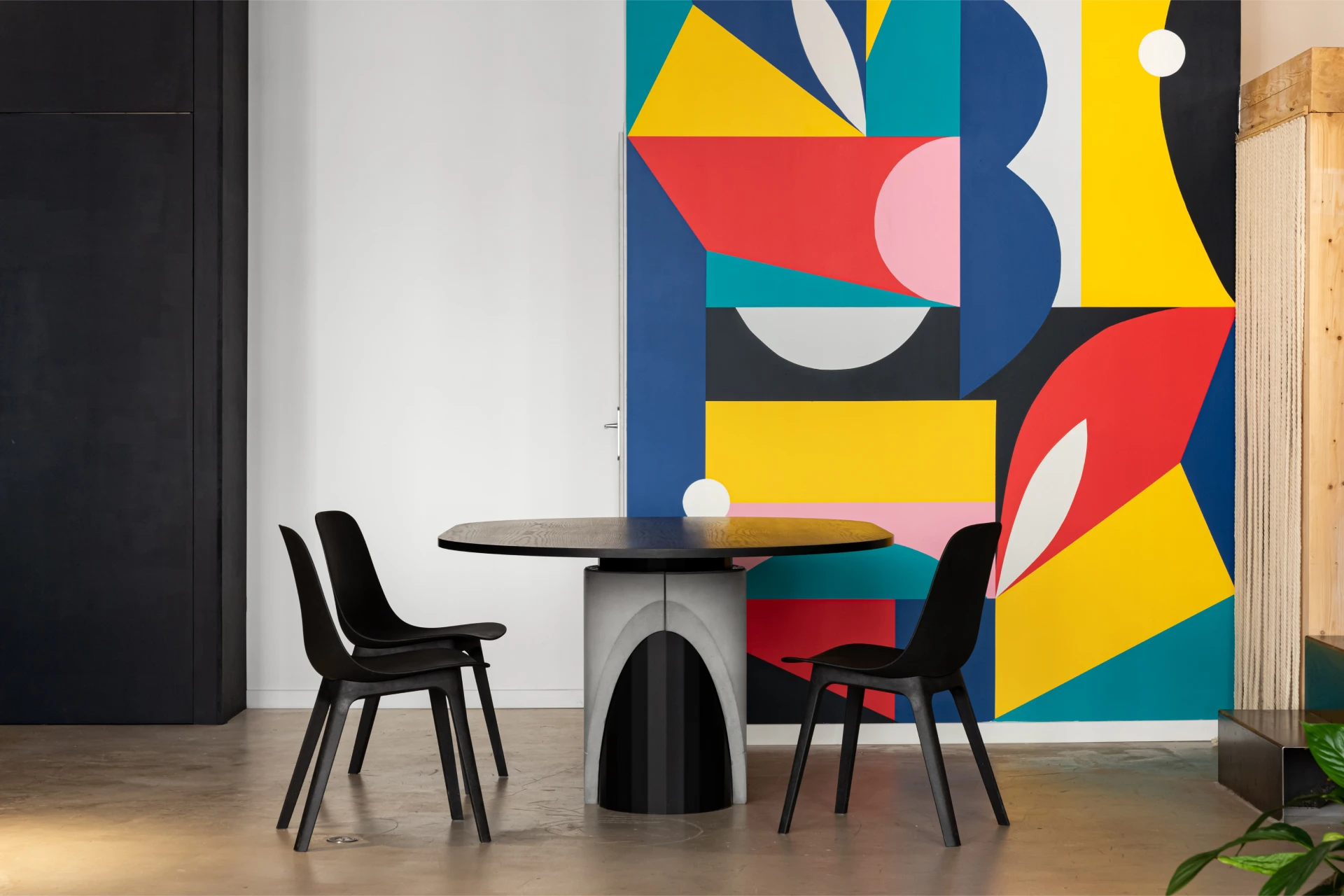 Dining table for 6 to 8 people black tinted wooden table top and metal and concrete foot for a modern and brutalist style. Inside Evol office at Lyon with Poter's artwork.