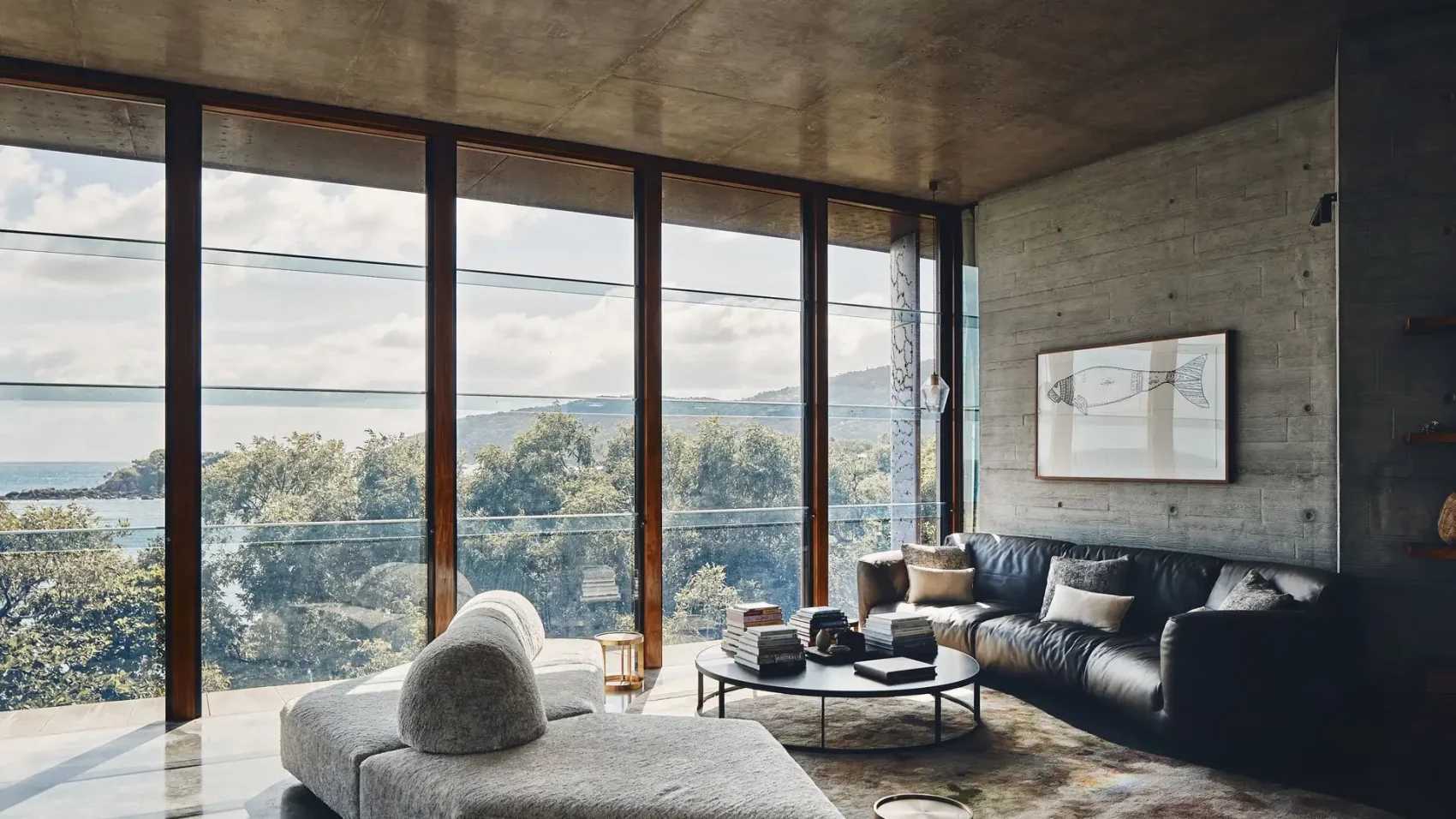 Contemporary living room with brutalist furniture and panoramic floor-to-ceiling window