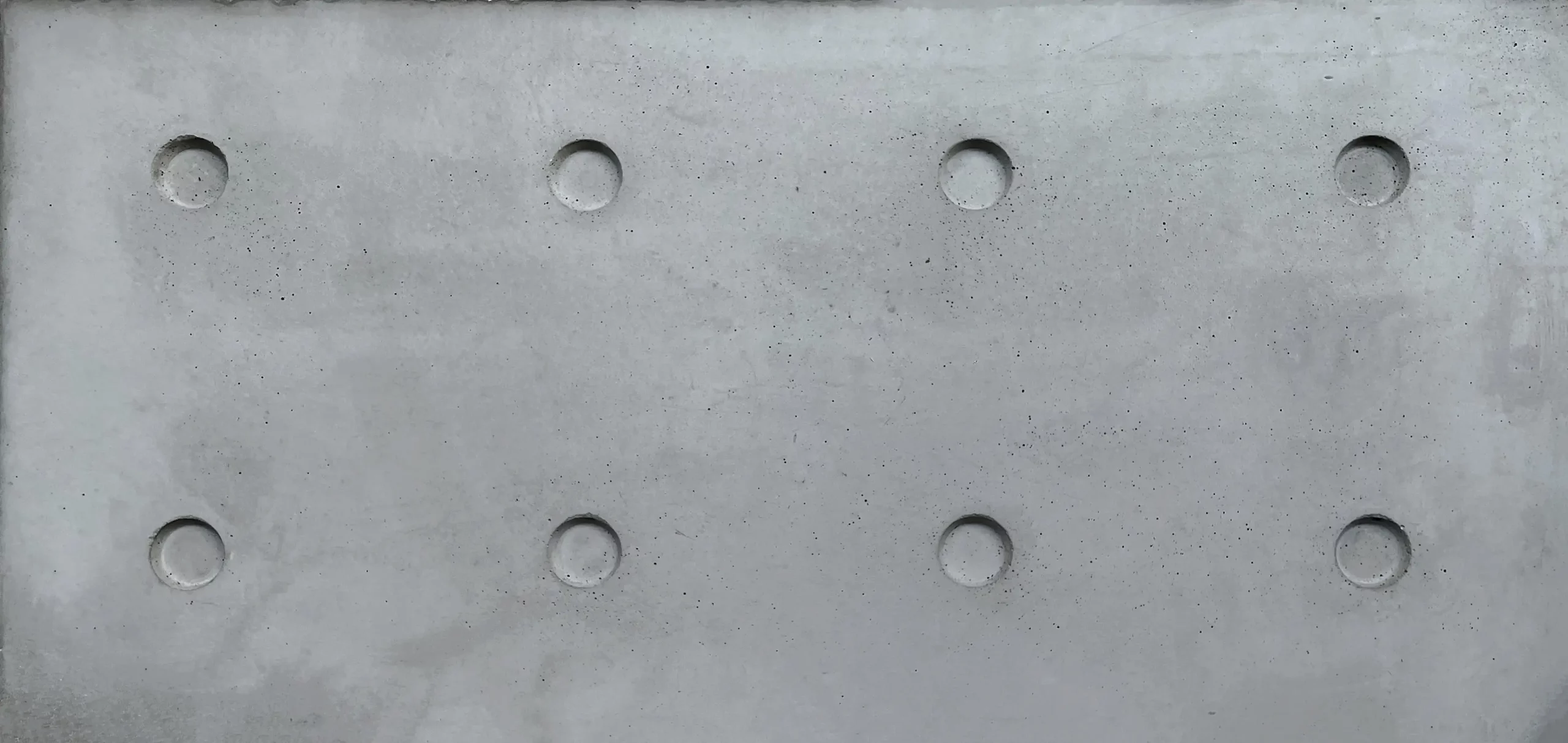 Perforated raw concrete surface, natural texture of a Lyon Béton design furniture piece