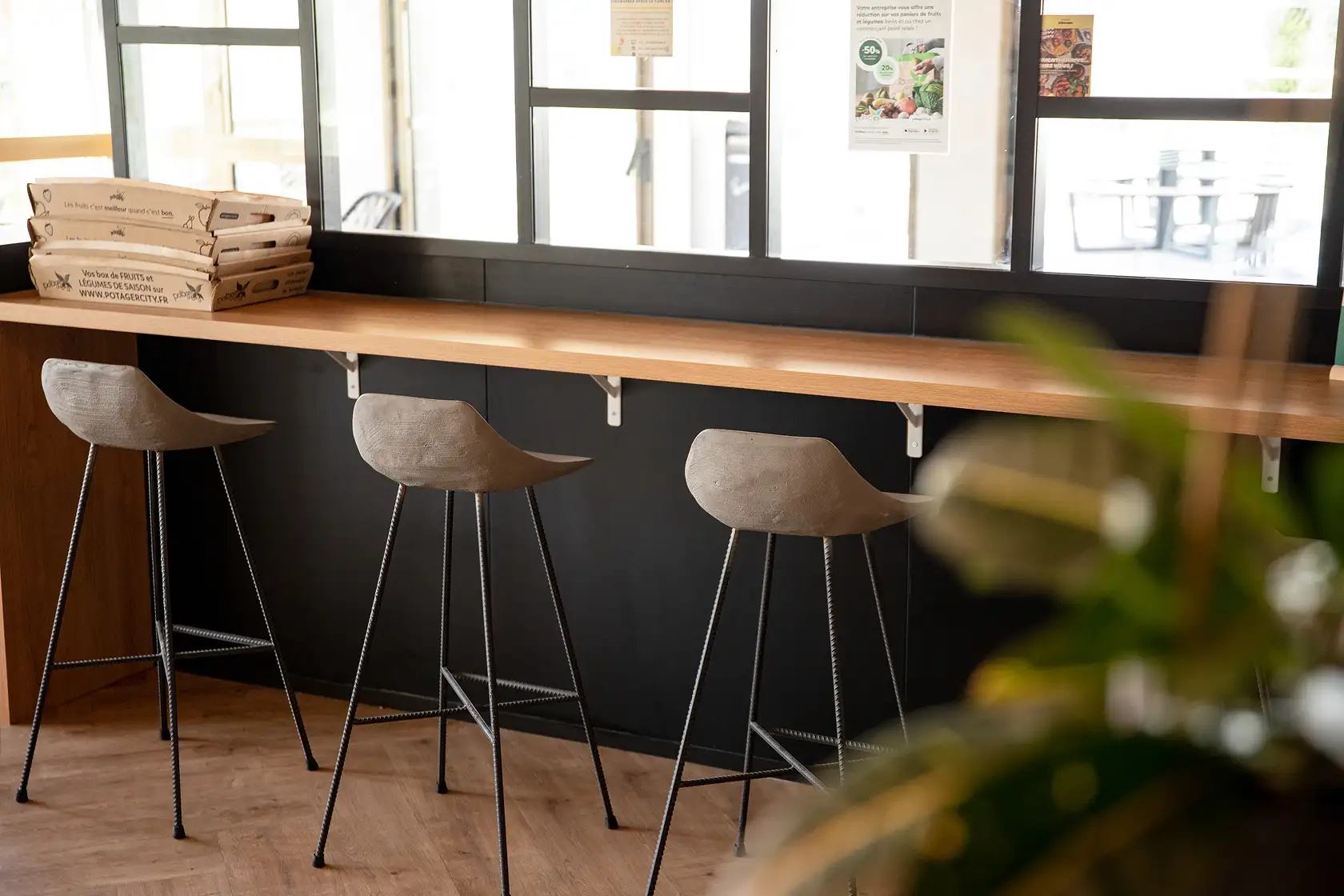 Hauteville concrete stools in front of a wood counter on herringbone parquet — Lyon Béton
