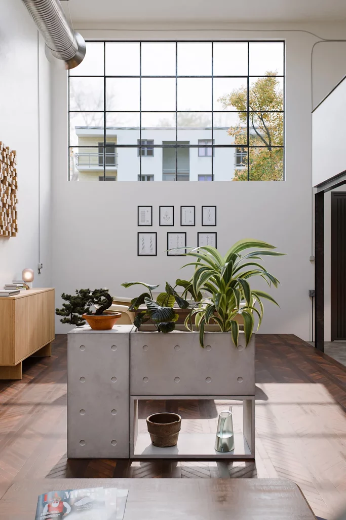 Concrete Dice modules assembled as a planter with plants, in a loft under a large window.