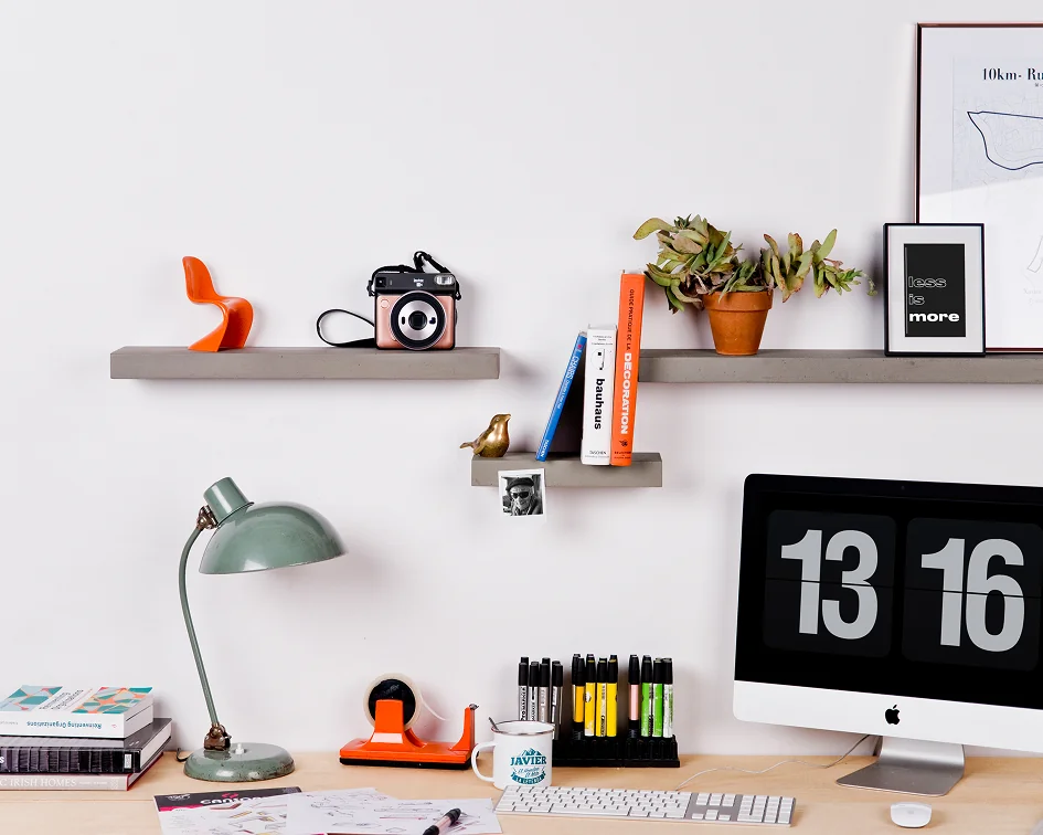 Sliced concrete wall shelves above a wooden desk